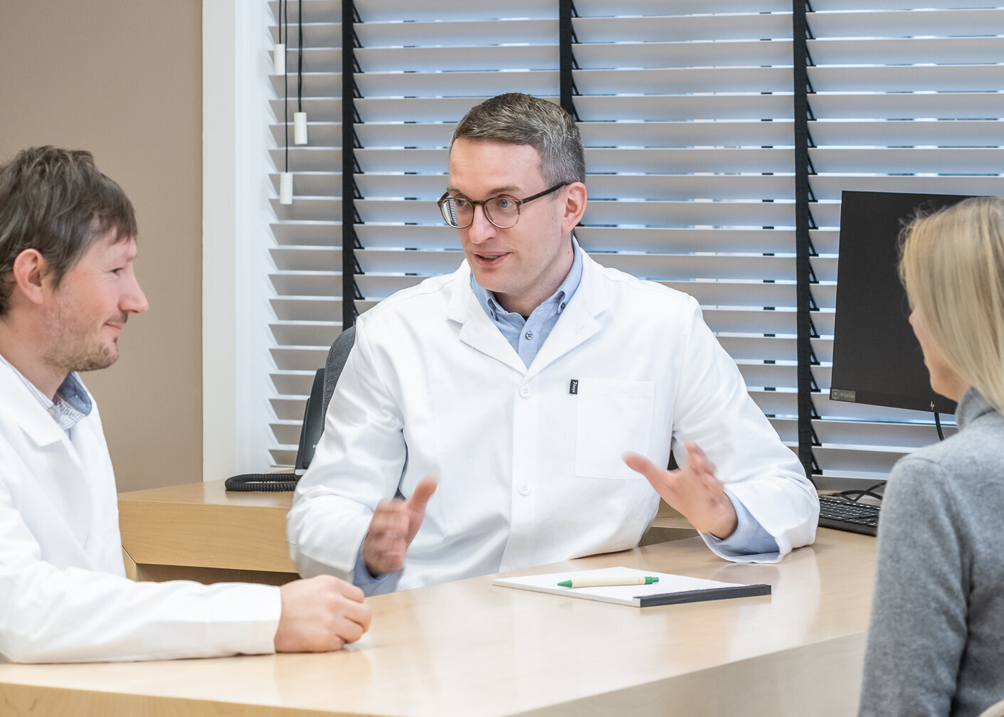Die Neurologen Dr. Ilijas Jelcic und Dr. Nikolai Pfender sitzen am Schreibtisch und besprechen etwas.