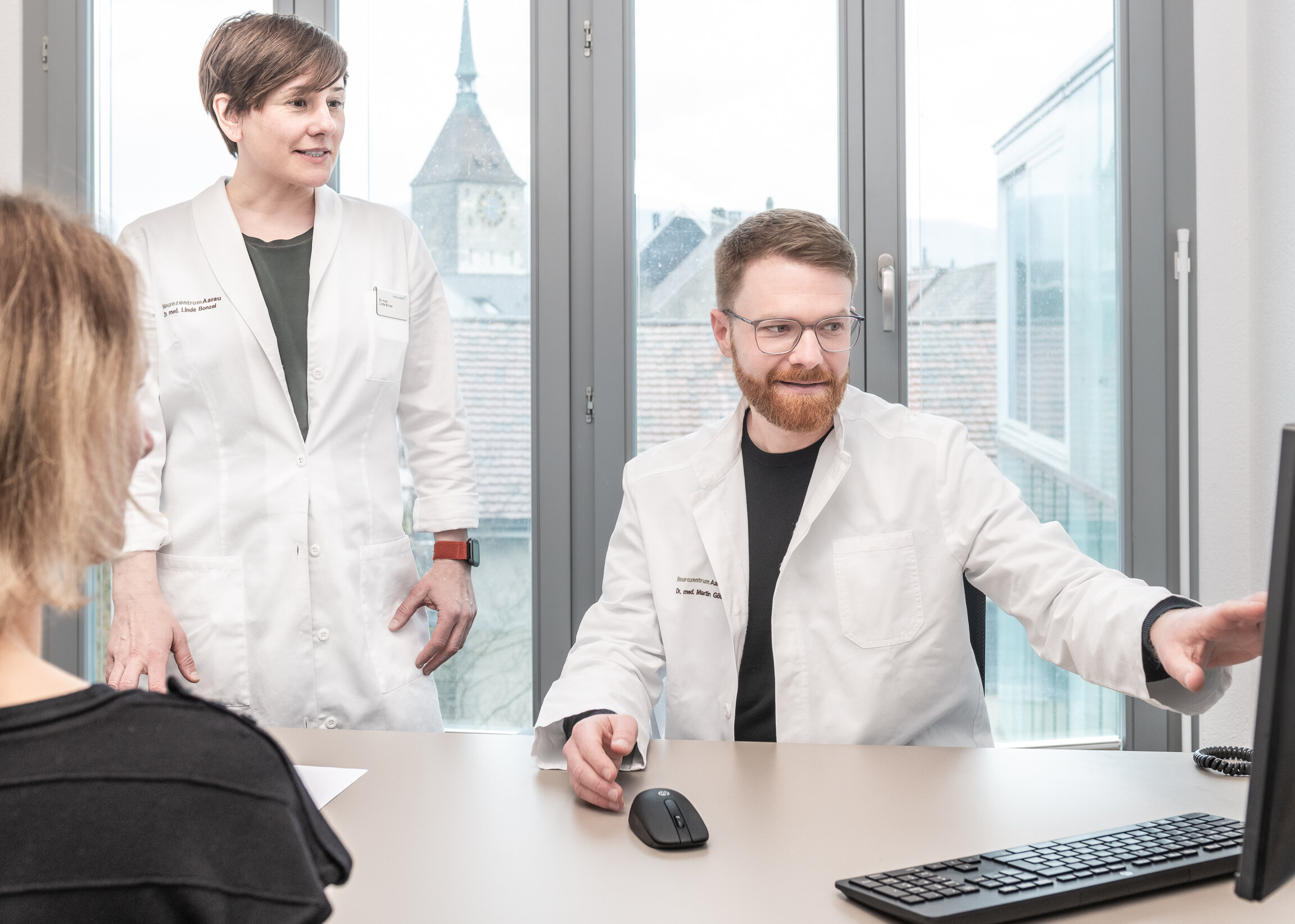 Der Neurologe, Dr. Martin Gölzer zeigt der Neurologin Dr. Linda Bonzel etwas auf seinem Bildschirm.