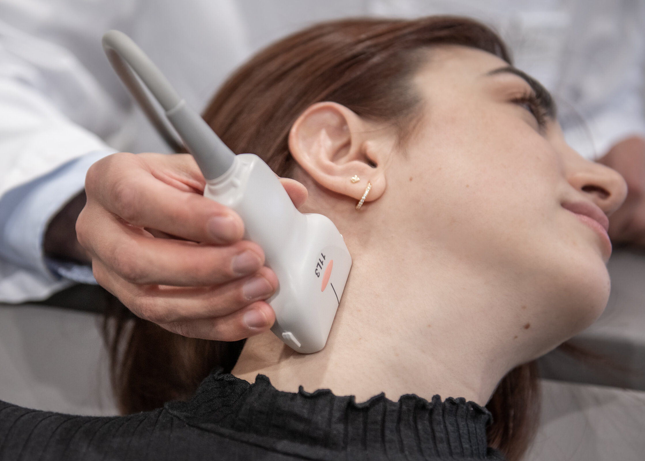 Eine Dopplersonografie wird am Hals einer Patientin durchgeführt.