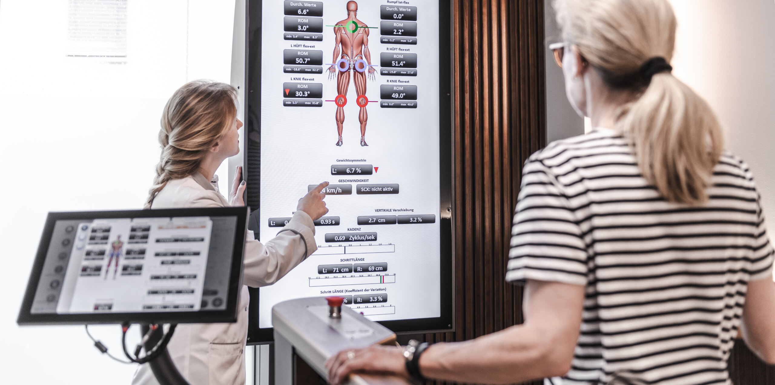 Eine Mitarbeiterin des Ganglabors erklärt einer Patientin die Ergebnisse auf einem Bildschirm.